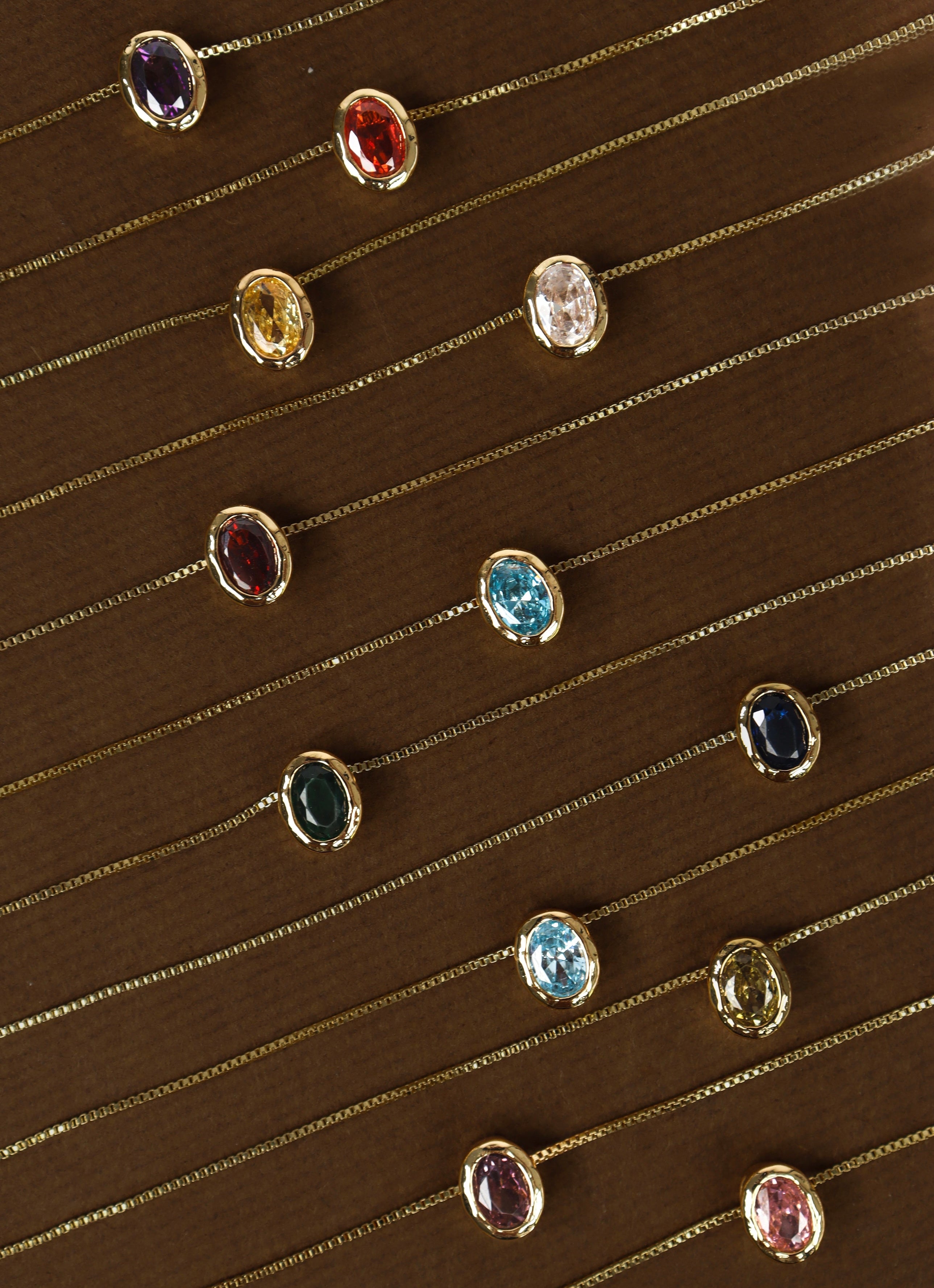 Beautiful gems birthstone necklaces in gold layed out and made for gifting